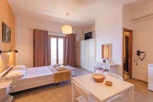 a bedroom with a bed and a table at Dimitra's Studios in Stoupa +9 photos