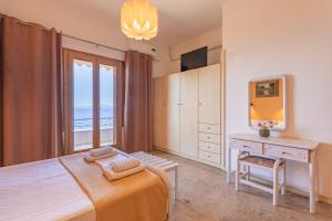 a bedroom with a bed and a desk and a window at Dimitra's Studios in Stoupa
