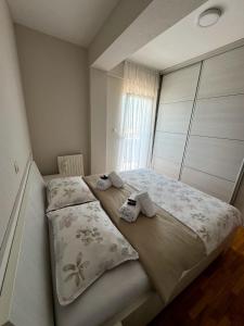 een slaapkamer met een bed met twee slippers erop bij Apartman Lončar Posušje in Posušje +25 foto's