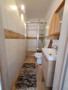 a bathroom with a sink and a toilet at Domki Apartamentowe 3Fale in Władysławowo +33 photos