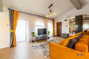 a living room with a couch and a television at Cozy Brand New Boutique ApartHotel Brasov in Braşov