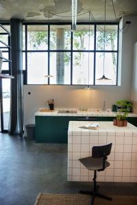 a large kitchen with a desk and a chair at Suvelfabryk in Lioessens +245 photos