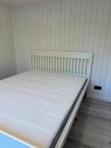 a white bed in a room with a mattressvisor at Melluži tiny house 60m2 in Jūrmala