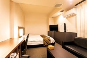 a hotel room with a bed and a desk and a couch at Hotel Double Funabashi in Funabashi
