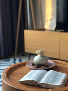 un tavolo di legno con un piatto e un libro aperto di Sky Suites KLCC by Psalm Space exclusively for female travellers a Kuala Lumpur