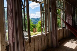 an empty room with windows and a view of the mountains at Rusikos guest house in Oni