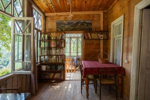 a room with a table and a book shelf with books at Rusikos guest house in Oni