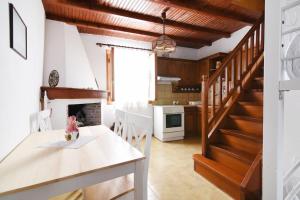 a kitchen with a table and a staircase in a room at Κυκλαδίτικη Μεζονέτα in Kithnos +17 photos