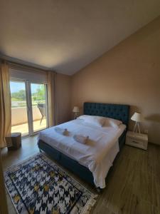 a bedroom with a bed and a large window at Sunrise house apartments in Ulcinj