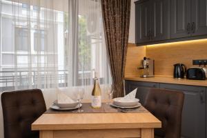 een tafel met een fles wijn en twee glazen bij Prestige Central Apartments in Varna