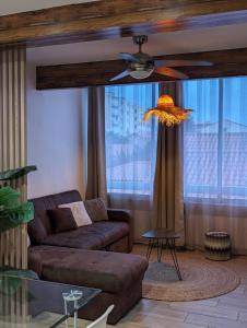 un salon avec un canapé et un ventilateur de plafond dans l'établissement - Voile -, à Canet