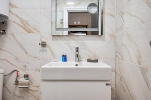 een badkamer met een witte wastafel en een spiegel bij Prestige Central Apartments in Varna +188 foto's