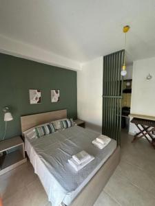 a bedroom with a bed with two pillows and a piano at Central Apart. 4U in Ierápetra
