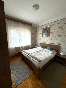 une chambre avec un grand lit et une fenêtre dans l'établissement Fejedelem Vendégház, à Eger