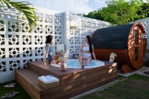 two girls in a hot tub in a backyard at The House By The Sea in Miyako Island