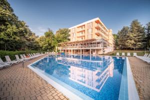 a building with a swimming pool in front of a building at Gloria Hotel - All Inclusive in St. St. Constantine and Helena