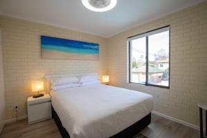 a bedroom with a large bed and a window at Charming 2-Bed Apartment with Bay Views in Batemans Bay +10 photos