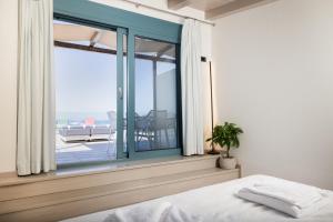 una camera da letto con finestra affacciata sull'oceano di Alas ad Argásion
