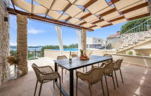 a dining room with a table and chairs on a patio at Nice Home In Zaboric With Wifi in Zaboric +39 photos