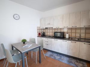 a kitchen with a table and a microwave at Magnolia House in Bellano