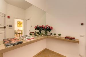 una habitación con un estante con flores y libros en Gonfalone 6, en Roma