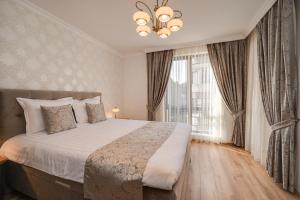 een slaapkamer met een bed en een groot raam bij Prestige Central Apartments in Varna