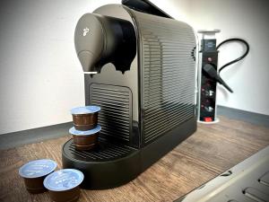 a coffee maker sitting on a table with three cups at Pures Wohlfühlen mit privater Sauna & Garten in Meschede +18 photos