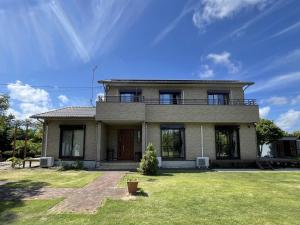 a house with a balcony on top of a yard at Kujukuri Green Garden Villa - 九十九里 グリーンガーデン - in Yokoshibahikari
