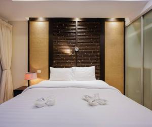 a bedroom with a large white bed with two towels on it at Seaview Condo with Large Pool - BAP1 in Phuket Town