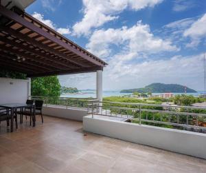 a balcony with a table and a view of the ocean at Seaview Condo with Large Pool - BAP1 in Phuket Town