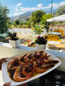 a plate of food with shrimp on a table at Natural Hostel in Himare +35 photos