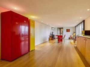 a living room with a red cabinet and a kitchen at Tokkijib Stay in Gyeongsan