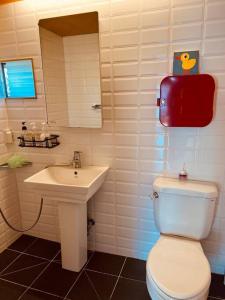 a bathroom with a white toilet and a sink at Tokkijib Stay in Gyeongsan