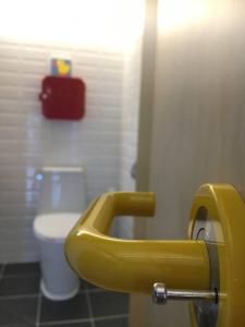 a bathroom with a yellow toilet paper dispenser on the wall at Tokkijib Stay in Gyeongsan +36 photos