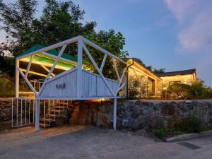 a house with a staircase next to a stone wall at Tokkijib Stay in Gyeongsan