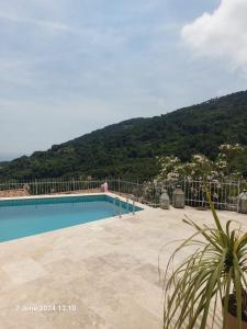 a swimming pool with a mountain in the background at Family Home - Between Monaco, Menton & Gorbio - Beautiful in Gorbio