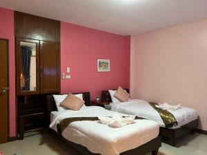 Ban Krabi Yaiโรงแรมตะวันไท的红色墙壁客房的两张床