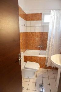 Un baño con inodoro, bañera y lavabo. en Photo gallery apartment, en Kavala 17 fotos más