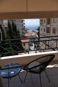 Un balcón con dos sillas y vista a una ciudad. en Photo gallery apartment, en Kavala