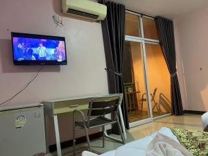 a room with a desk and a tv on the wall at โรงแรมตะวันไท in Ban Krabi Yai