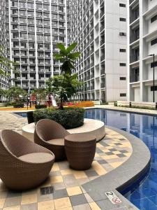 a courtyard with chairs and a pool in a building at E & R Staycation Condotel near Mall of Asia in Manila