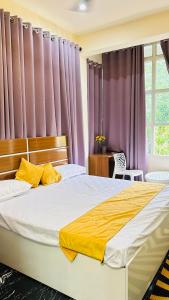 a bedroom with two beds and purple curtains at Himaksh Homestay in Varanasi