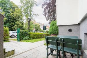 a green bench sitting next to a building at Villa Superiq Victus Sopot Walk to the Pier by Noclegi Renters in Sopot