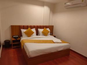 a bedroom with a large bed with yellow pillows at Hotel golden tree in Hisār