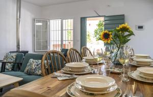 une salle à manger avec une table avec des assiettes et des verres dans l'établissement Cozy Home In Villanueva Del Río Y M, à Villanueva del Río y Minas