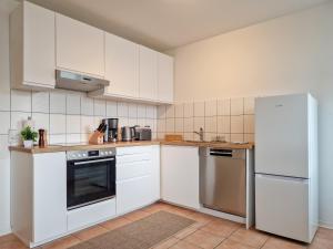 een keuken met witte kasten en een koelkast bij RR - NEW - Apartments Kappel - 85qm - Lift - WIFI in Chemnitz
