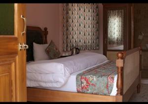 a bedroom with two beds and a window with curtains at KothiPushkar in Pushkar