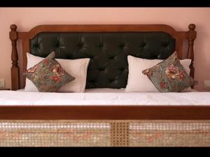 a bed with a black headboard and pillows on it at KothiPushkar in Pushkar