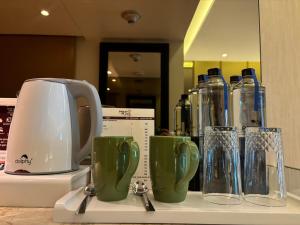 a counter with a toaster and some cups and glasses at Pride Plaza Hotel, Aerocity New Delhi in New Delhi