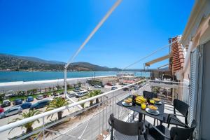 einen Balkon mit einem Tisch und Hafenblick in der Unterkunft Porta nel Blu in Argostoli
